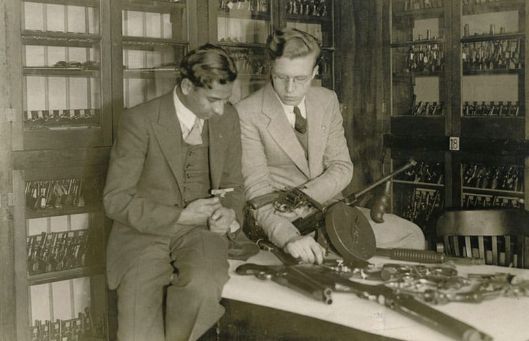 Goddard in room with shelves lined with weapons